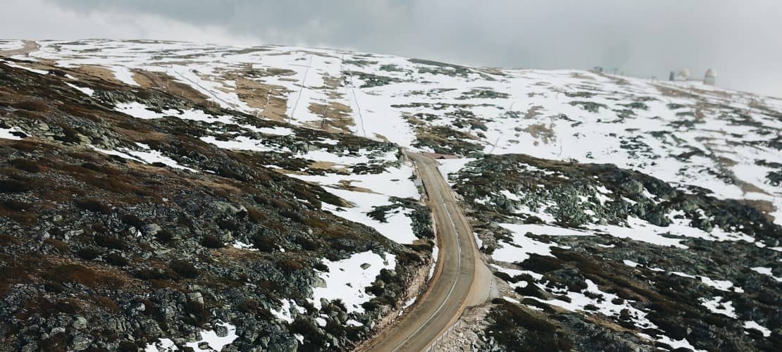 estrada na montanha com neve nas encostas