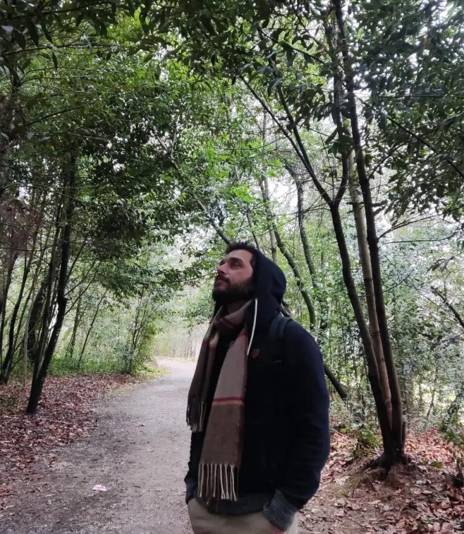 Homem a contemplar a floresta numa postura introspectiva