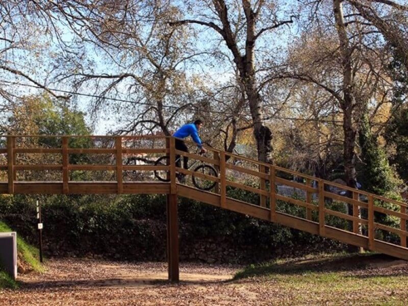 ciclista numa ponte de madeira