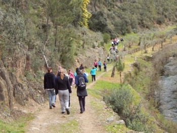 grupo de pessoas a caminhar na margem do rio unhais