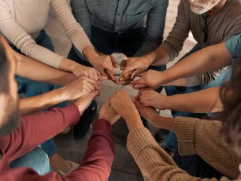 grupo de pessoas a dar as mãos no centro