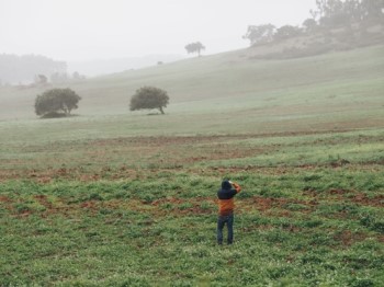 homem tirar fotografias de uma encosta da serra de montejunto num dia de nevoeiro