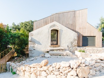 hotel boutique com arquitetura moderna rodeada por muro de pedras