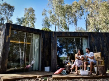 casal no pátio de uma casa em lousa no meio da floresta